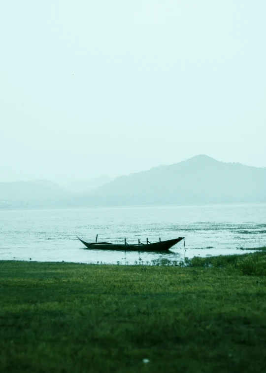 the man is rowing a boat out on the lake