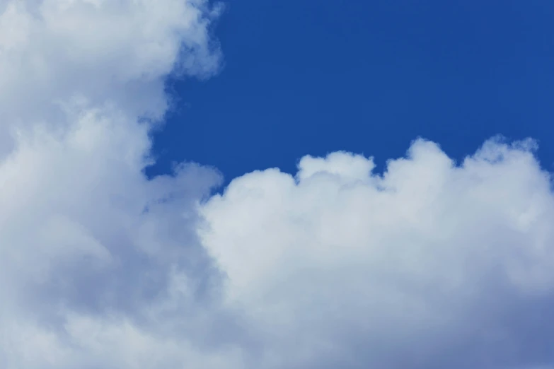 two airplanes in the sky with clouds behind them