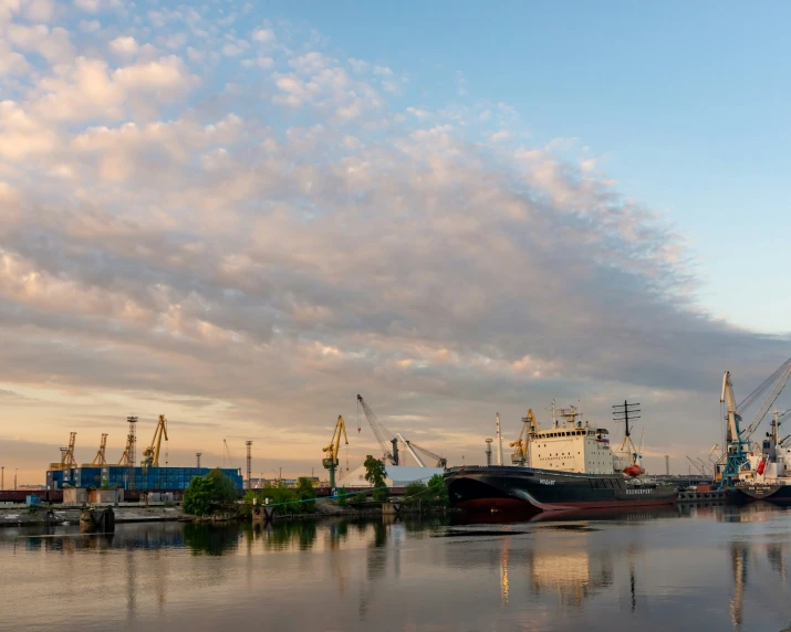 a ship is parked at a pier near other boats