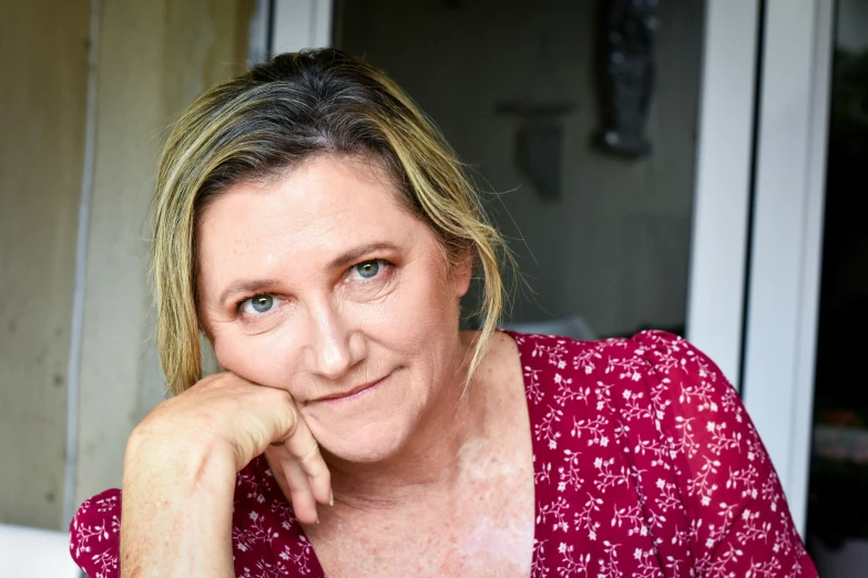 a women who is sitting down with a smile on her face