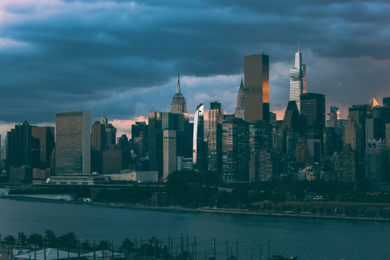 view of city skyline with clouds and lake