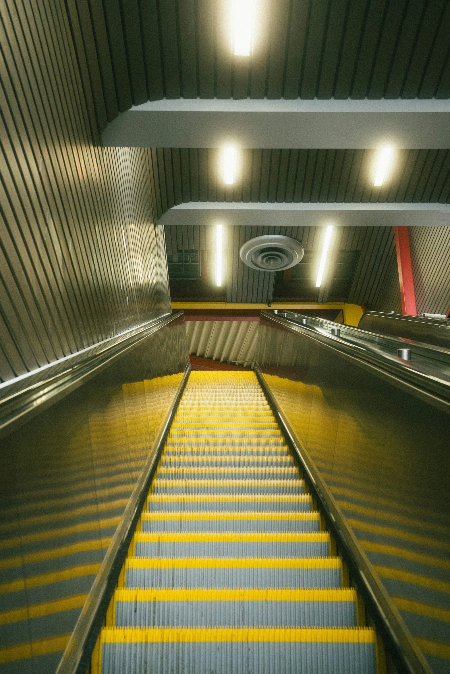 a stair going up to an escalator in a subway station