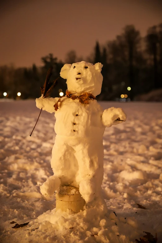 a snow man with poles in its mouth, in the middle of a snow field