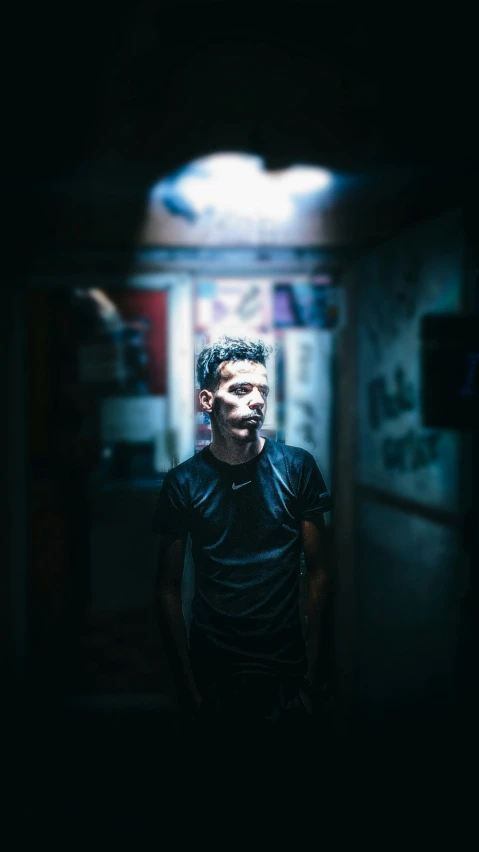 a man standing in a dark hallway with a black background