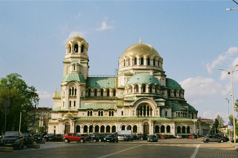 a large building with a massive domed top and many cars parked in front
