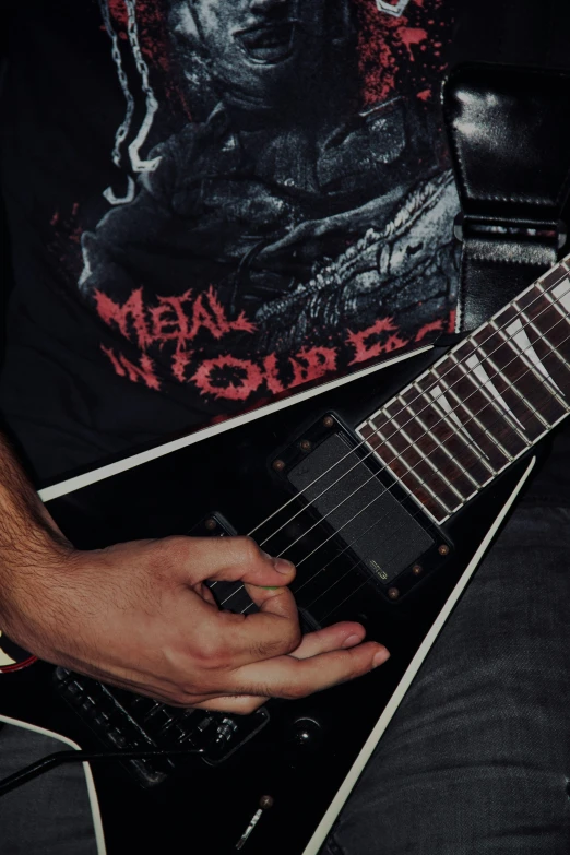 a person holding a guitar neck near their hand