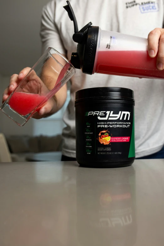 a person pouring red liquid into a cup