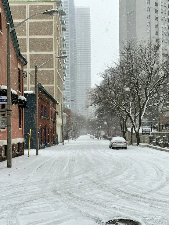 a street is shown with snow and buildings on it