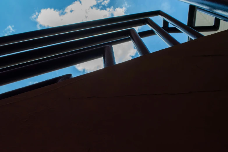 a black metal railing against a bright blue sky