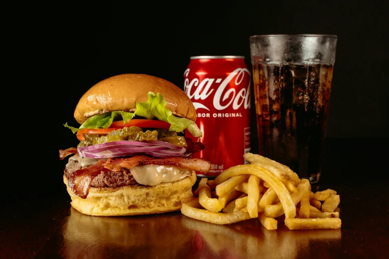 a hamburger sitting next to some fries and a coca cola