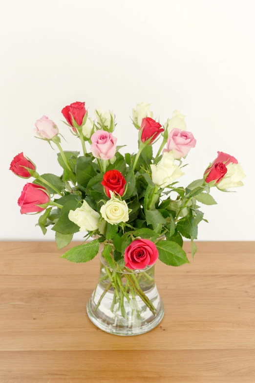 a vase with some red and white flowers in it