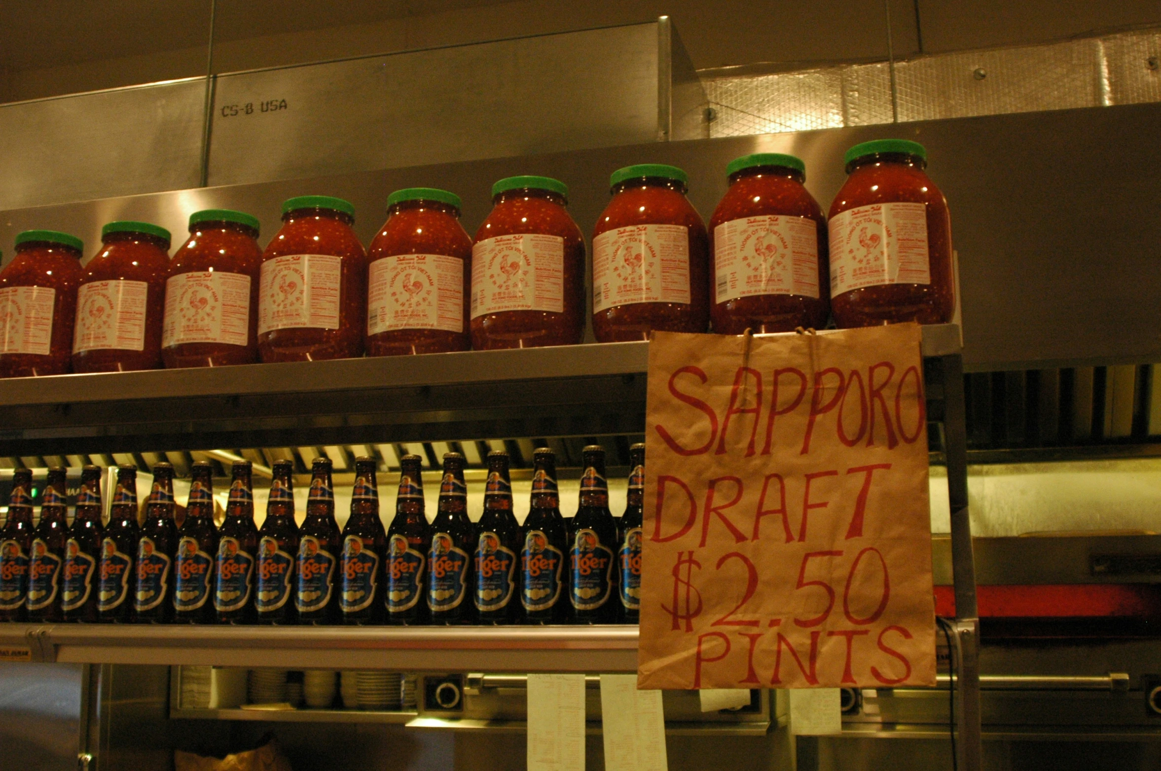 bottles of red, white and green sauce on shelves