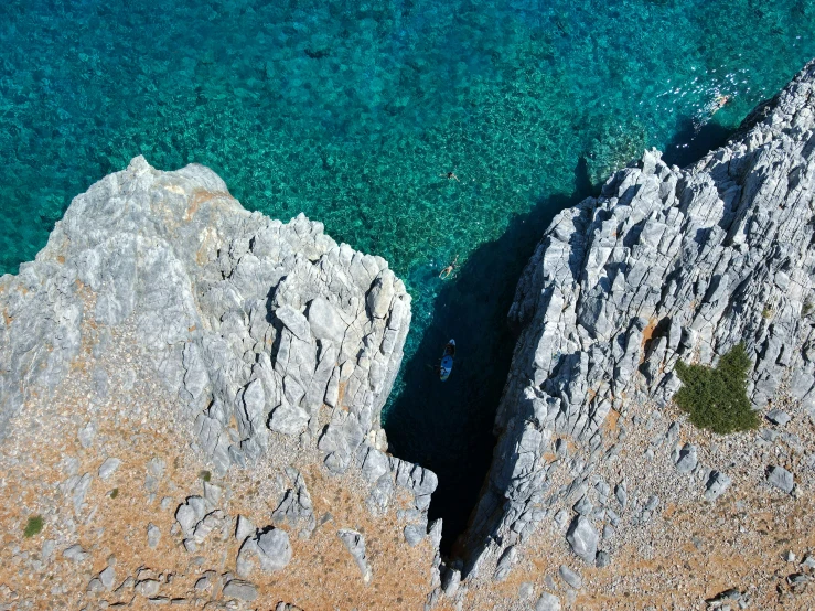 two people are walking along an area of rocks