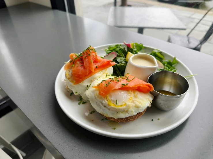 plate of food on top of table next to cup and sauce