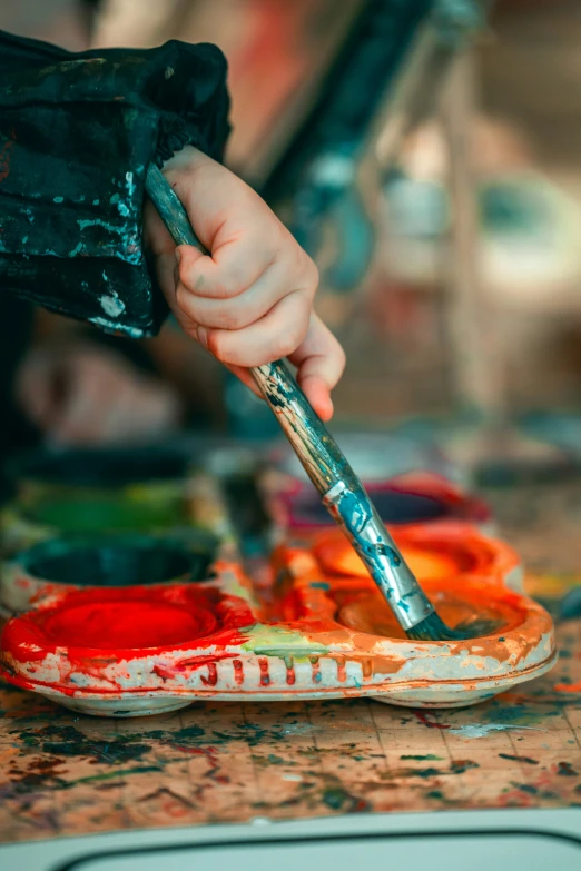 a person uses a paintbrush to decorate a miniature pair of shoes