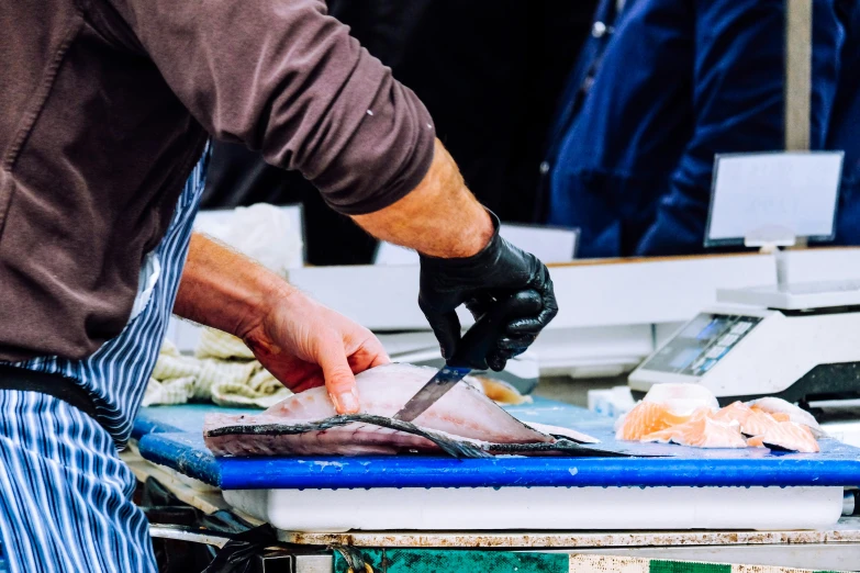 a chef with a knife and tongs preparing food