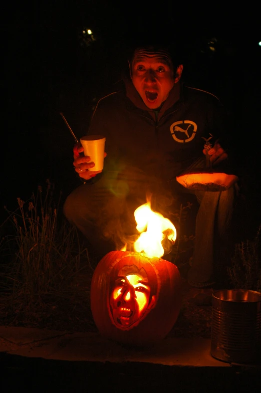 a man is sitting on the ground with his mouth open and holding a glass