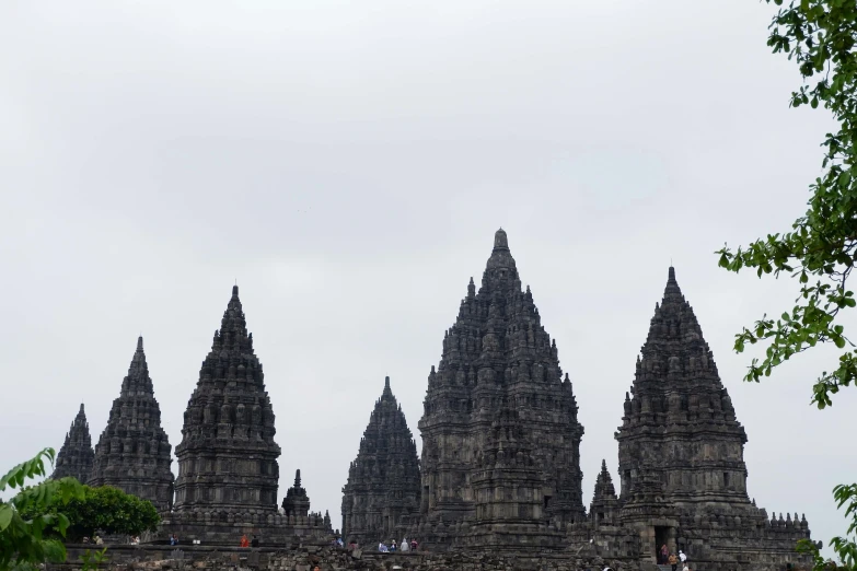 a bunch of tall towers standing behind a wall