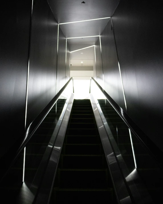 a very dark and dark escalator with some bright lighting