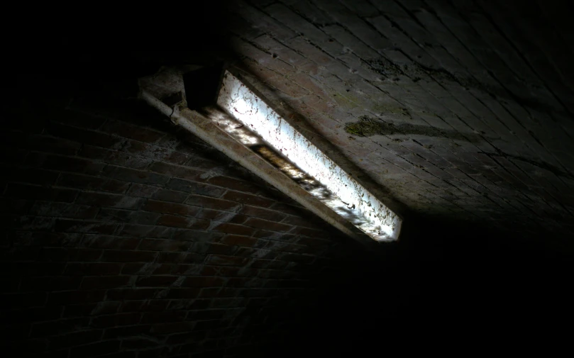 light shines brightly through a window that matches the brick wall