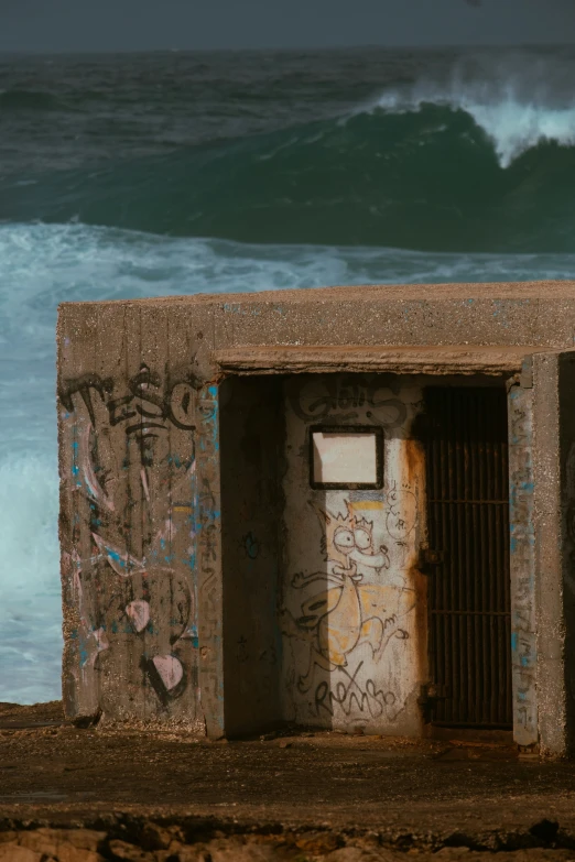 a graffiti covered wall next to the ocean