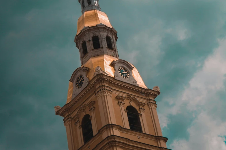 a clock tower stands against a cloudy sky