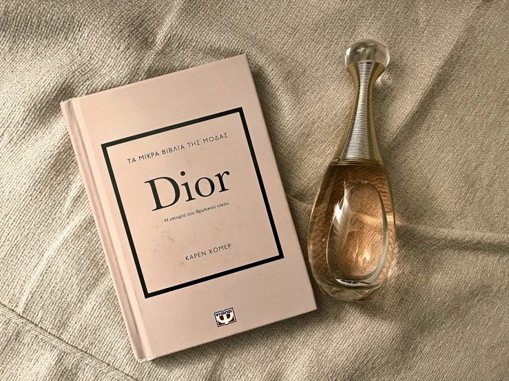 a bottle of perfume next to an open book
