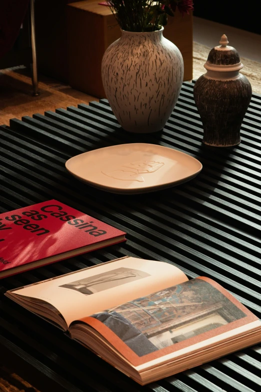 a table topped with two vases and books