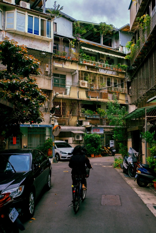 a person riding a bike down a street next to parked cars