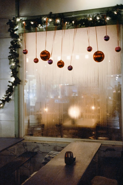 christmas decorations are hung on the window in the dark