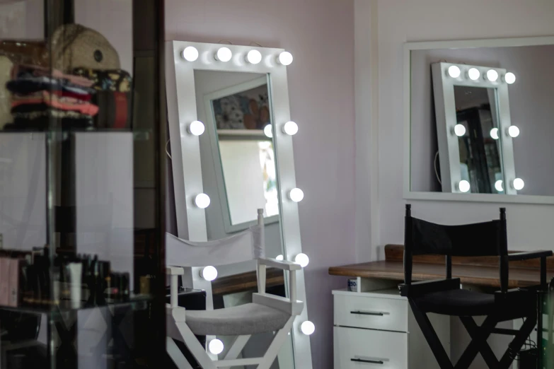 a mirror sitting in a room with a vanity and some lights on