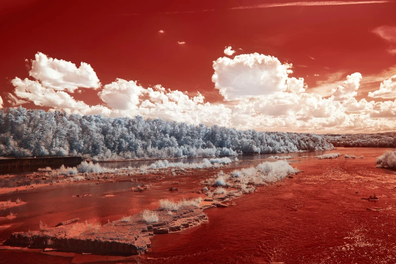 an abstract pograph of a red sky with a river running through it