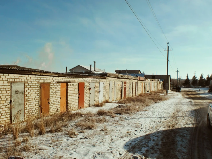 a truck parked next to a row of abandoned buildings