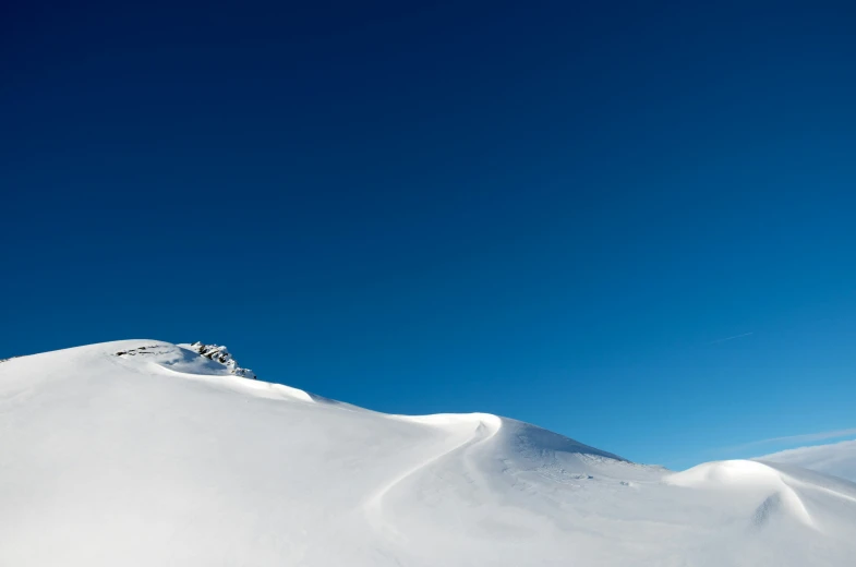 snow boarders on a snowy mountain during the day