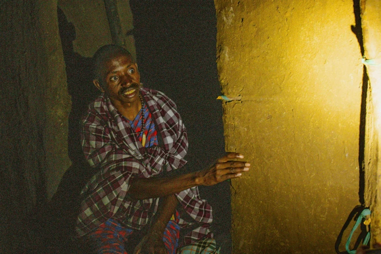 a man in a red and green checkered shirt standing next to a doorway