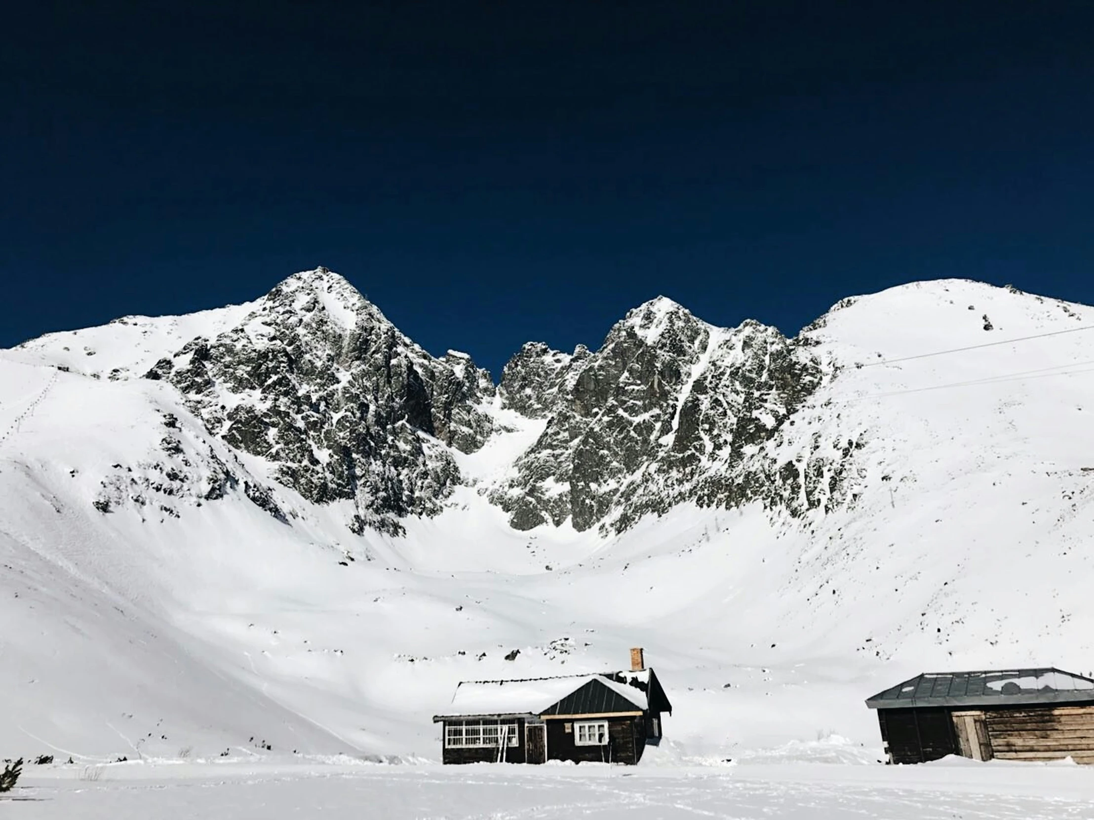 some mountains with snow and buildings in the foreground