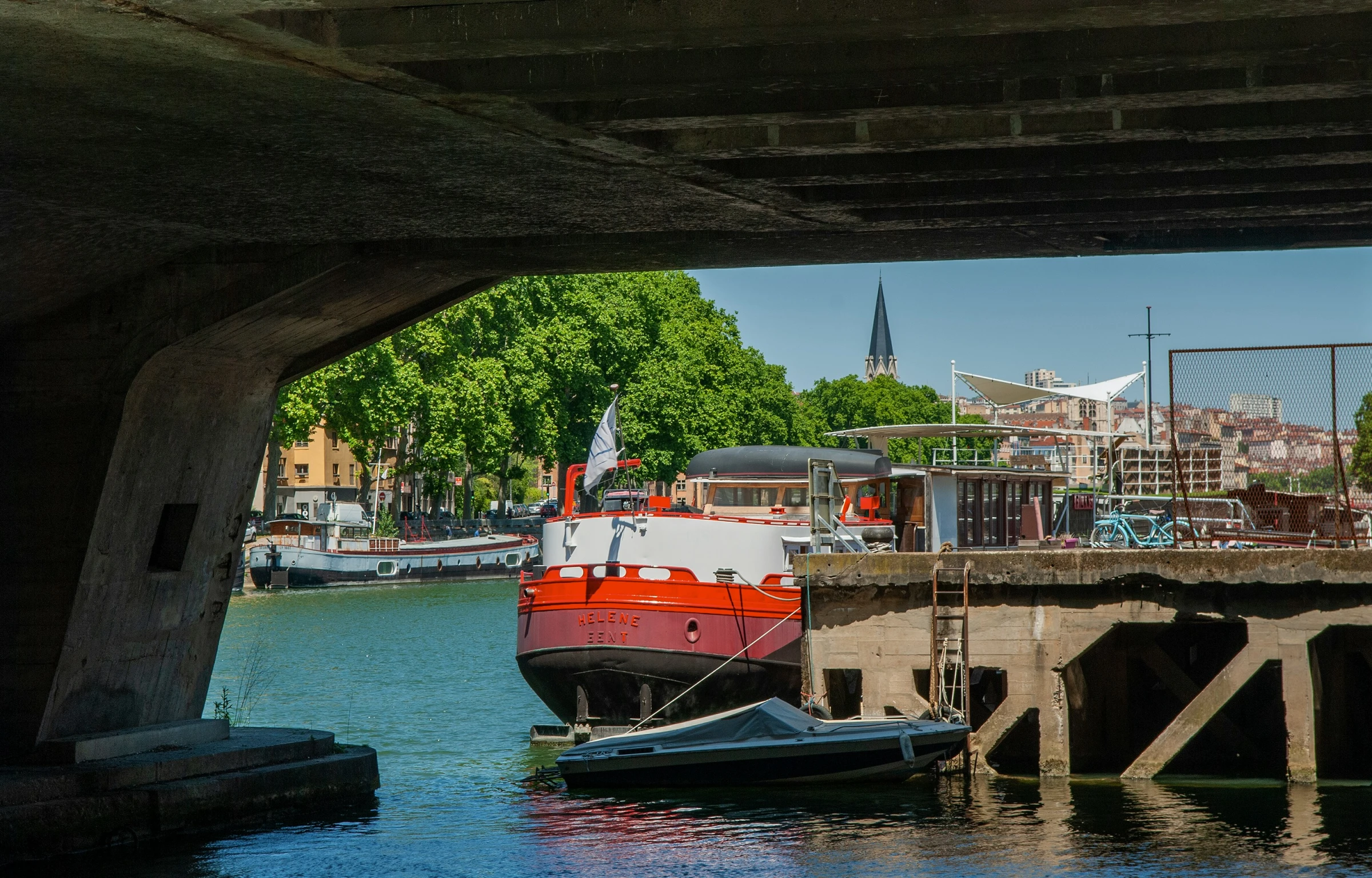 a boat is docked under the bridge in a body of water