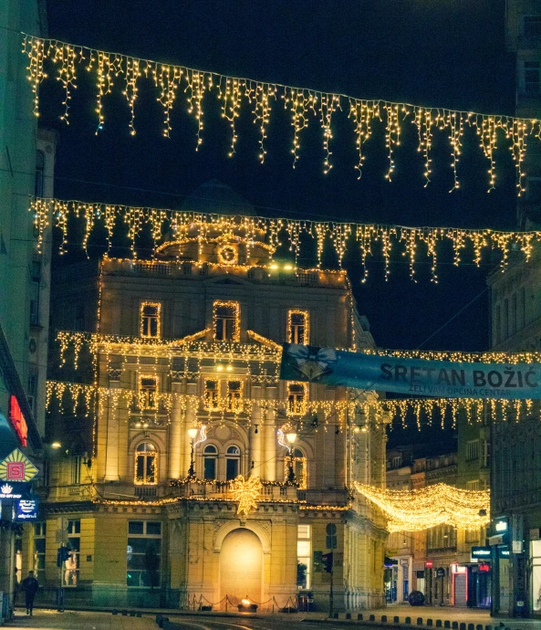 christmas lights adorn an old building on a city street