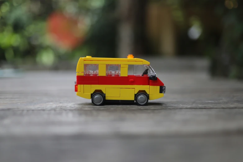 a toy bus parked on the ground next to some trees