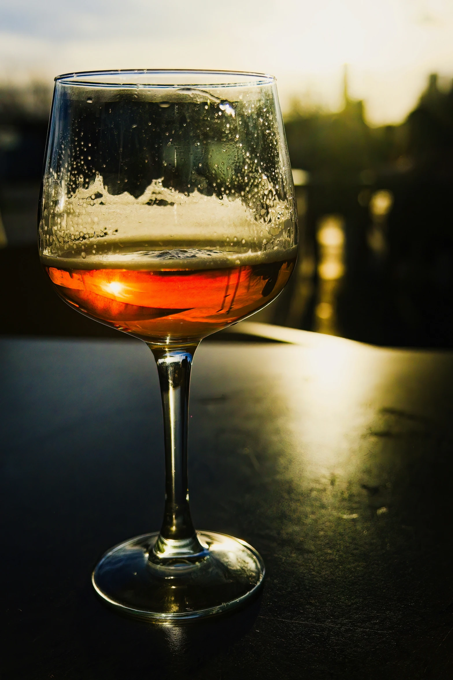 a glass filled with wine sitting on top of a table