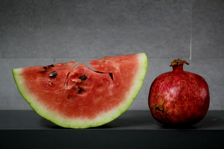 an apple and slice of watermelon sitting next to each other