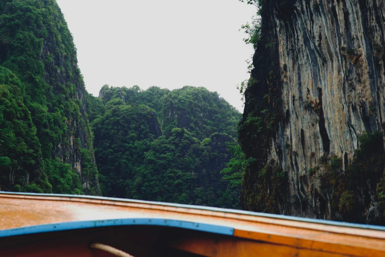 a long boat going down a river through the mountains