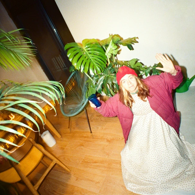 a girl with long red hair wearing a dress and hat with flowers