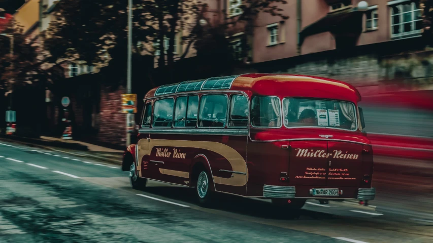 a red bus driving down a street next to tall buildings