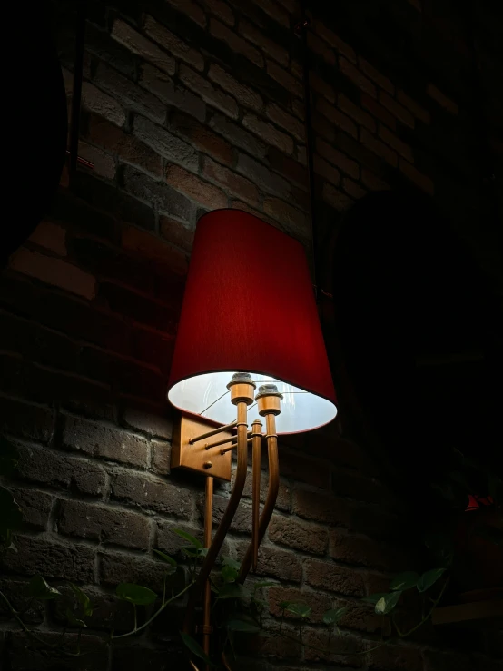 a close up of a wall lamp with a red shade
