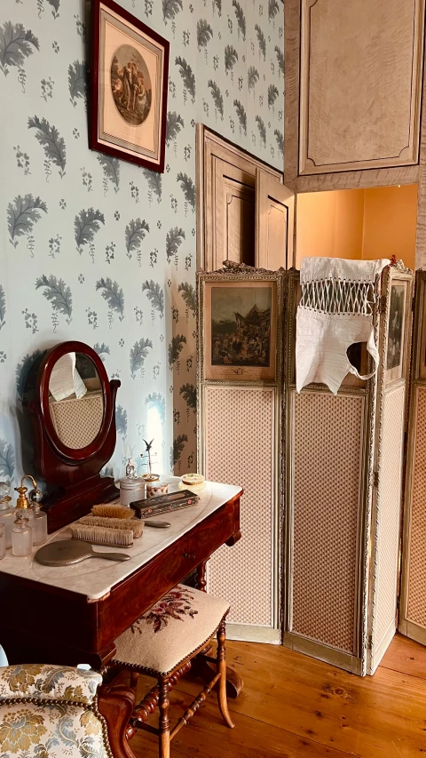 an old fashioned dressing table with mirror, stool, etc and clothes