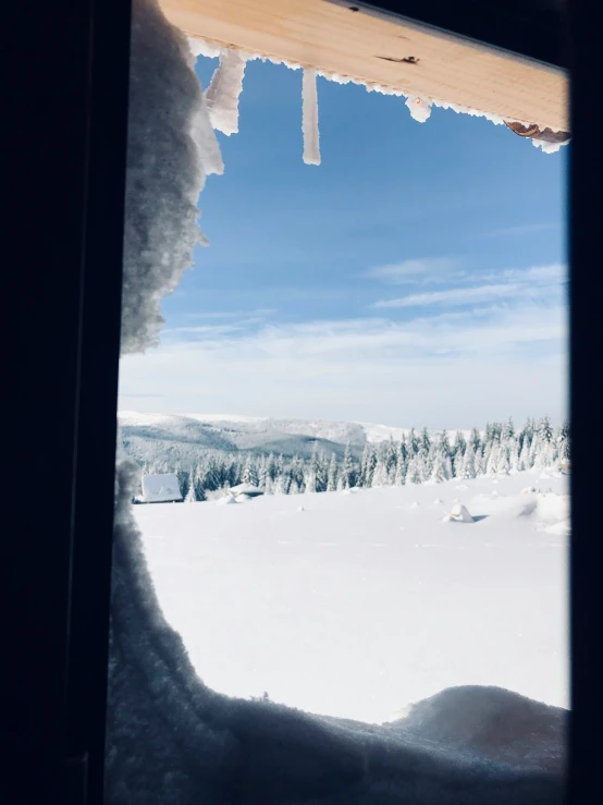 a view from inside a small cabin in the snow