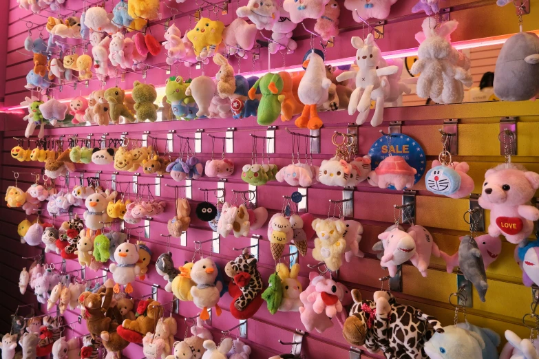 colorful teddy bears hang from a pink wall