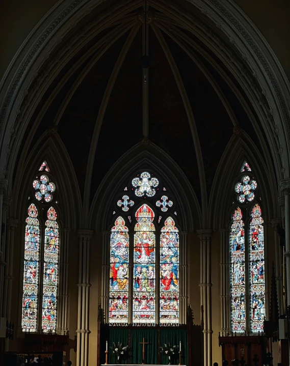 some people standing in front of two very large stained glass windows