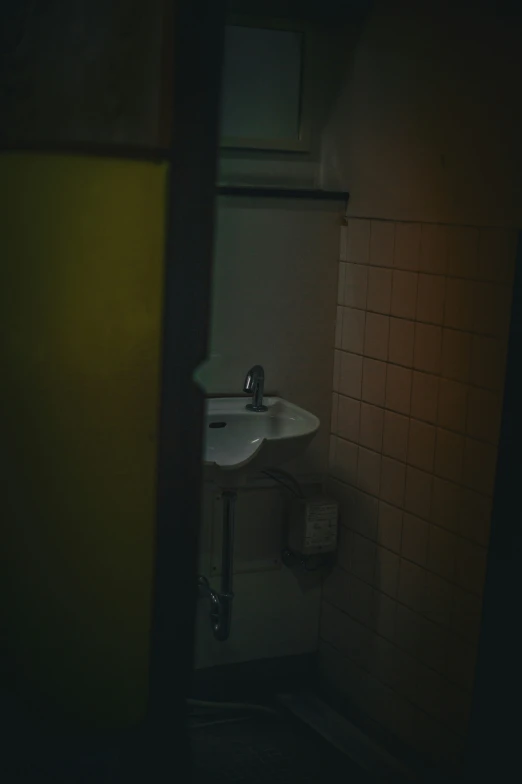 bathroom wall and sink with dark lighting in back